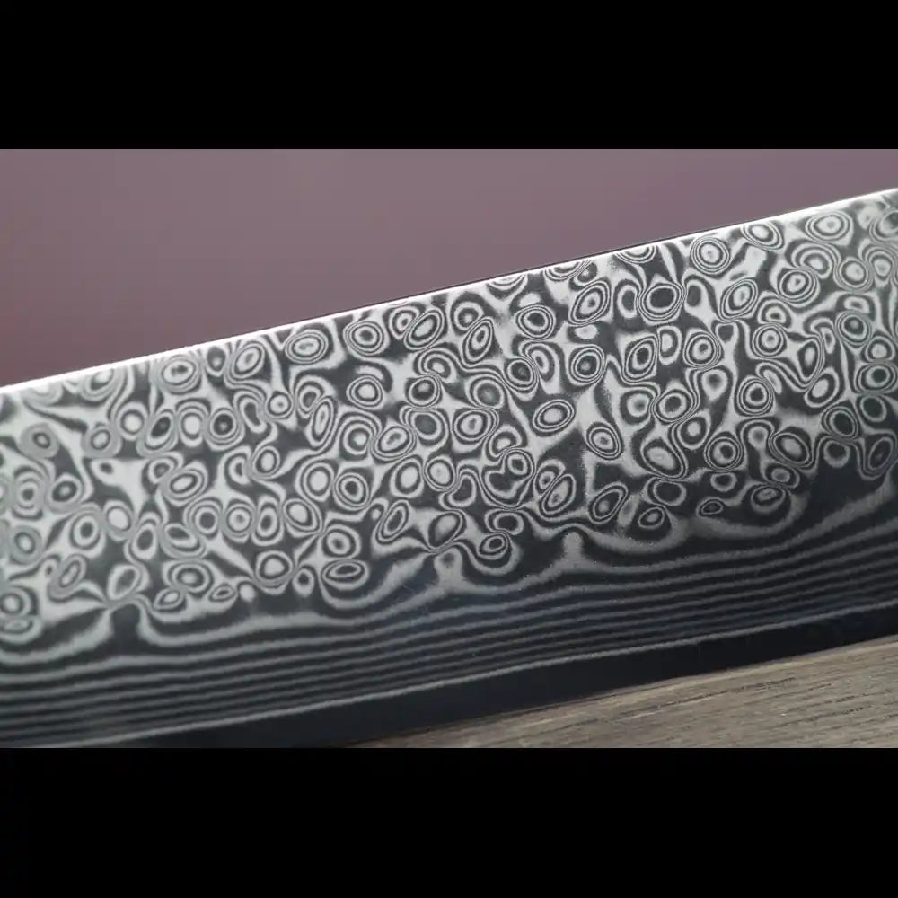 Damastmesser-Klinge mit VG10 Stahlkern und 67 Lagen Damaststahl in Detailansicht.