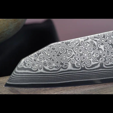 Santokumesser-Klinge mit VG10 Stahlkern und 67 Lagen Damaststahl in detaillierter Nahaufnahme.